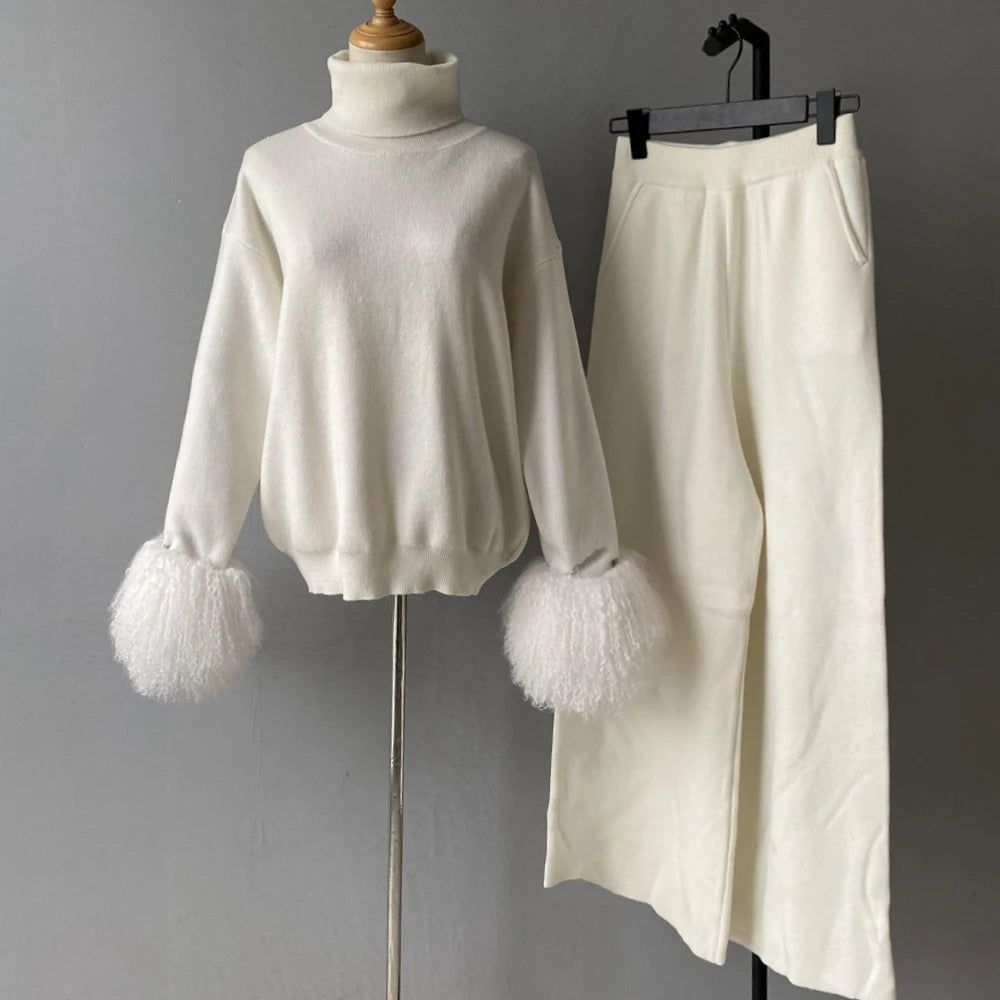 White sweater with fluffy cuffs and a matching skirt on a gray background