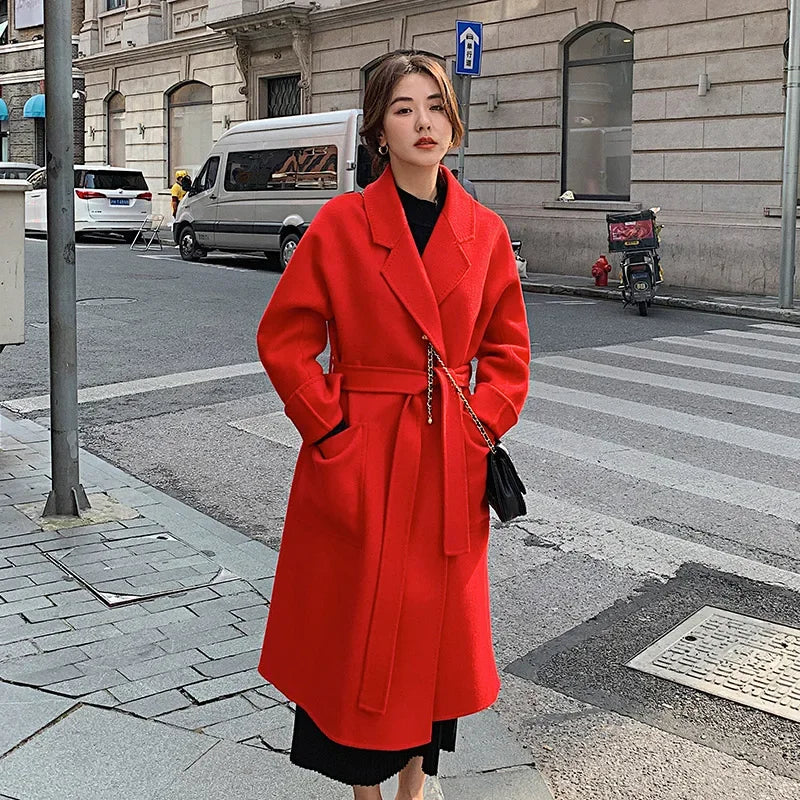 Woman in a red coat standing on a city street