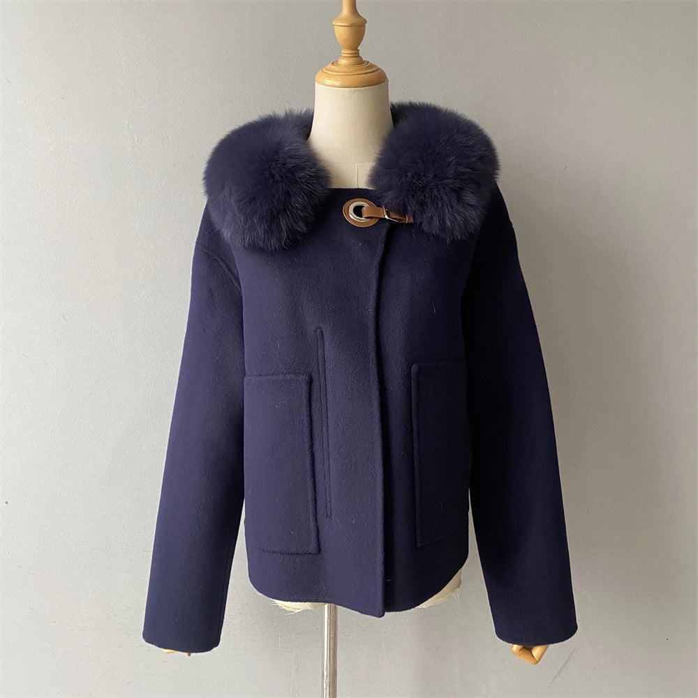 Navy blue coat with fur collar on a mannequin against a plain background