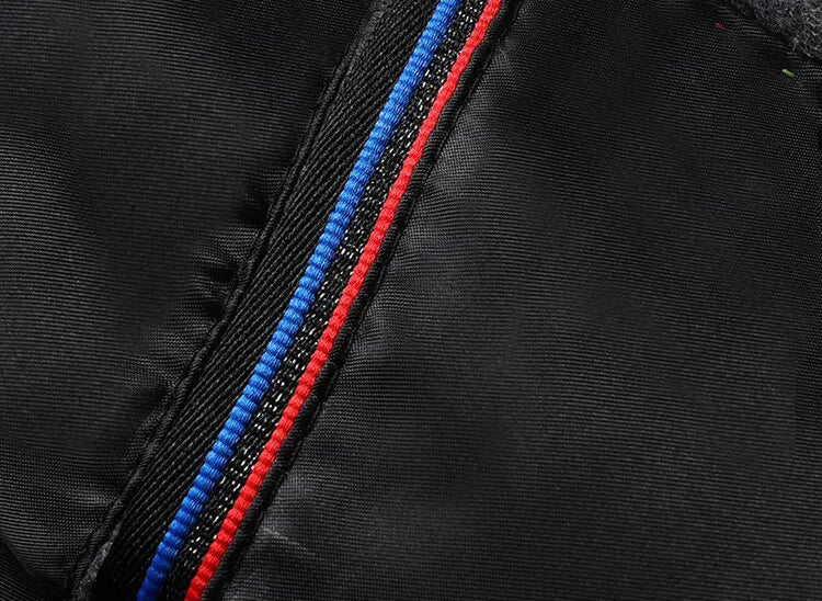 Close-up of a black jacket with blue and red zipper details