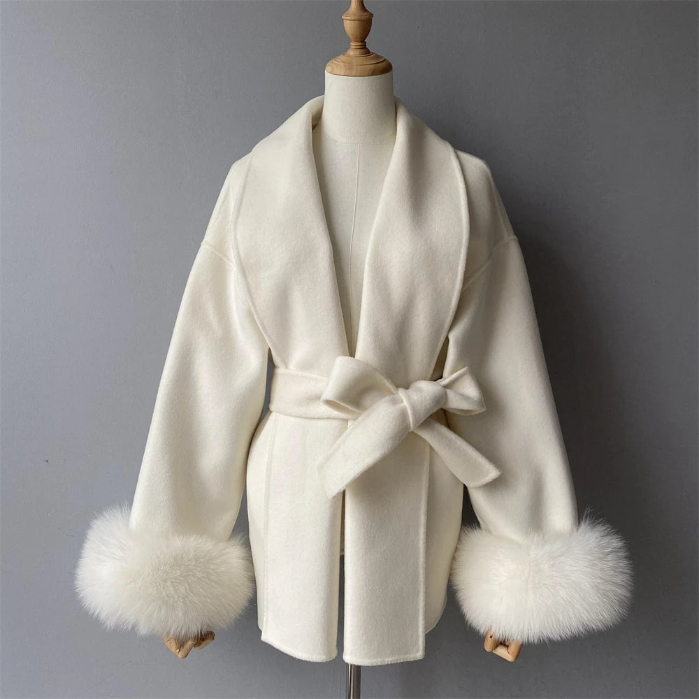 White coat with fur cuffs on a mannequin against a gray background