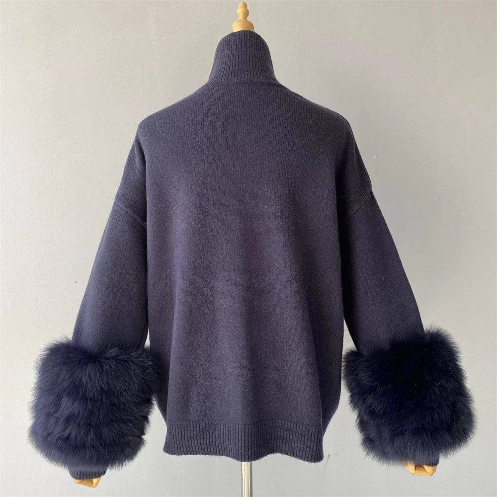 Dark blue sweater with fur cuffs on a mannequin against a plain background