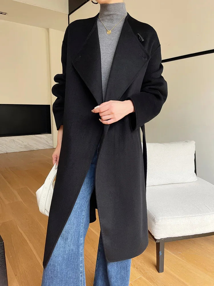 Person wearing a black coat in an indoor setting