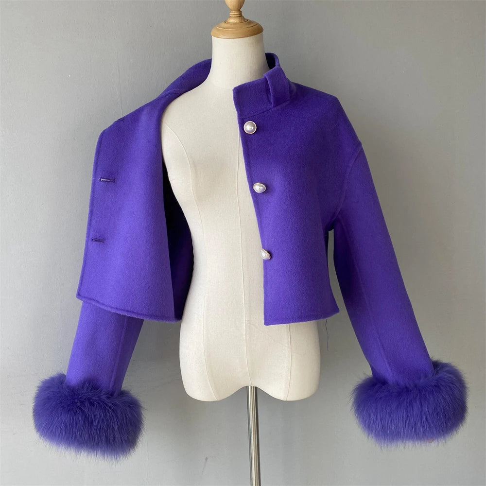 Purple coat with fur cuffs on a mannequin against a gray background