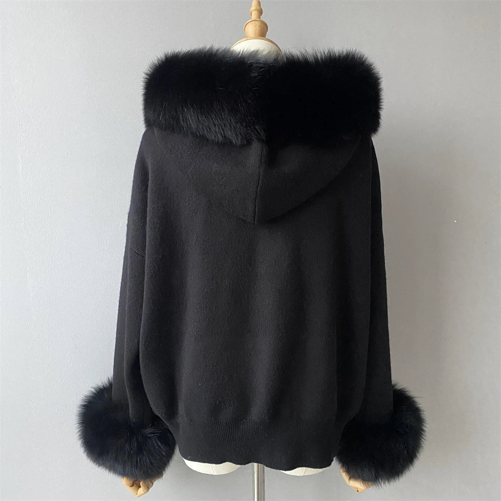 Black coat with fur trim on a mannequin against a plain background