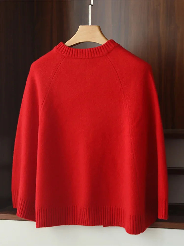 Red sweater on a wooden hanger against a dark background