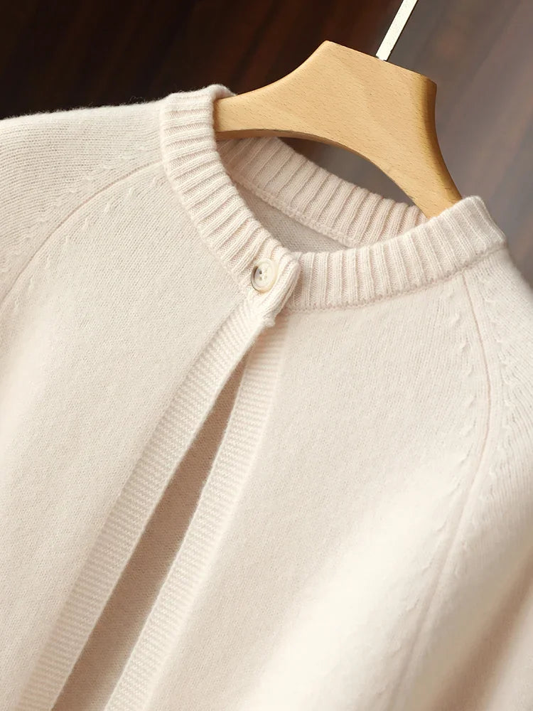 Beige sweater on a wooden hanger against a neutral background