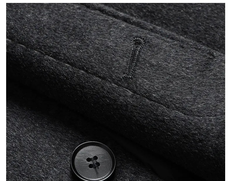 Close-up of a dark textured fabric with a button and brand logo.