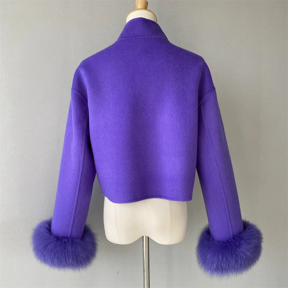 Purple jacket with fur cuffs on a mannequin against a gray background