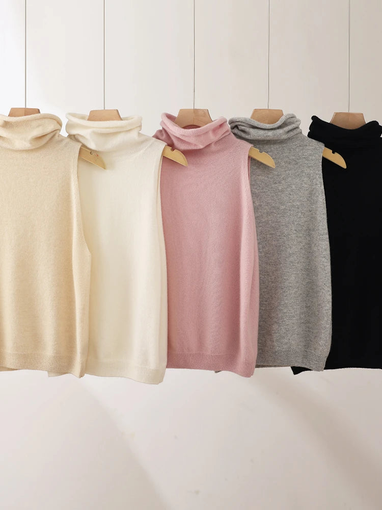 Five different colored turtleneck sweaters on wooden hangers against a white background.