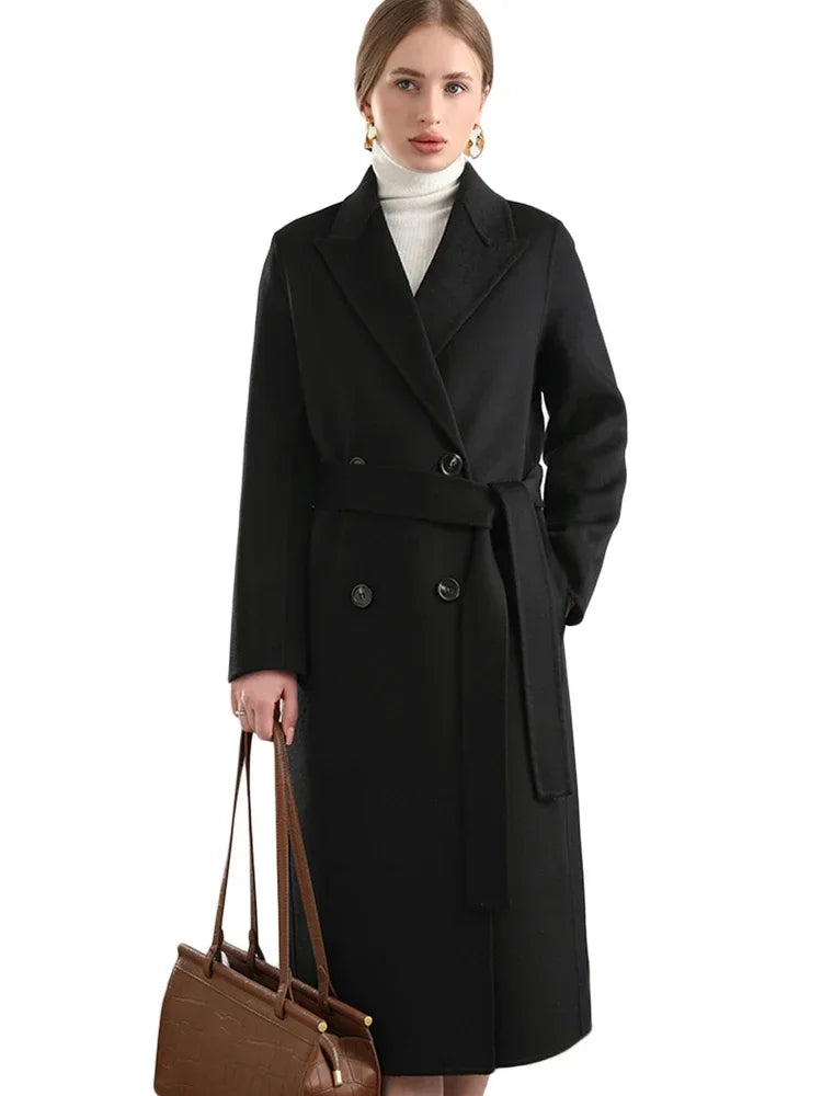Woman wearing a black coat holding a brown handbag on a white background