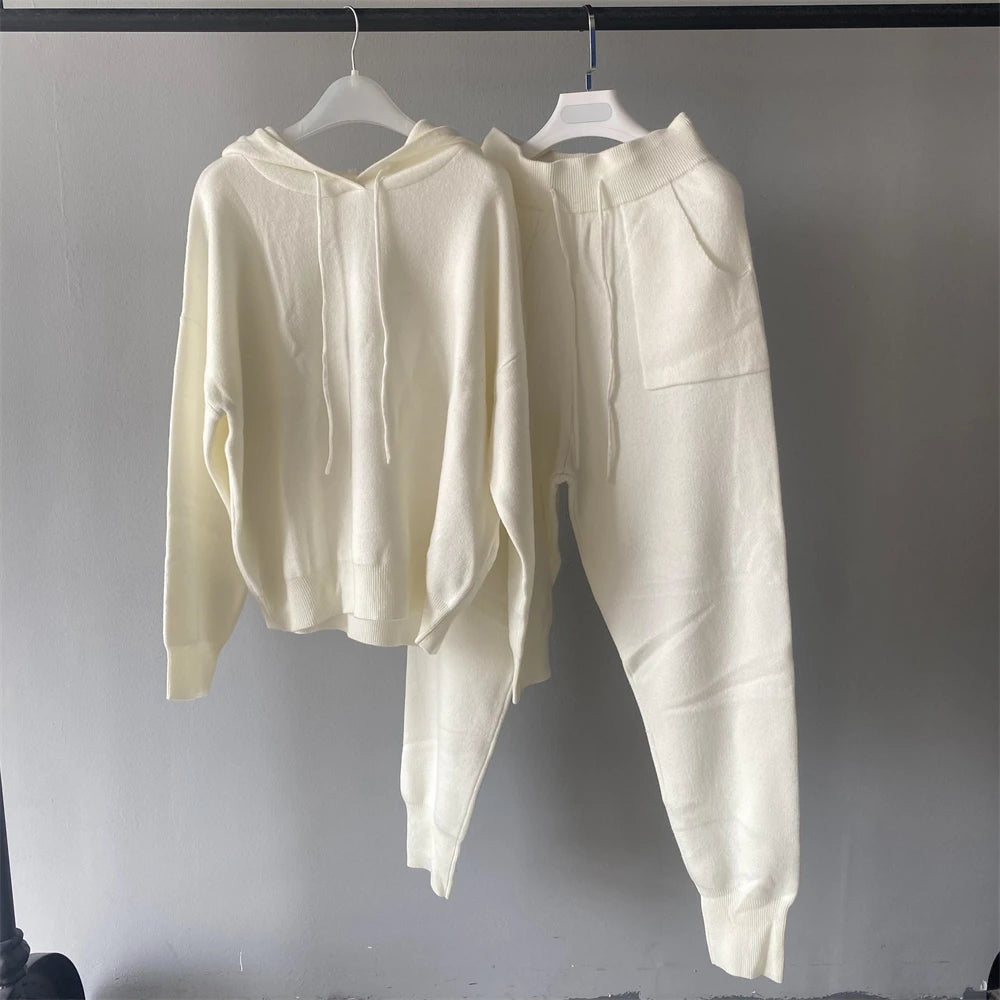 White hoodie and pants set hanging on a gray background