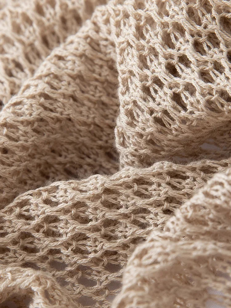 Close-up of beige knitted fabric with a textured pattern