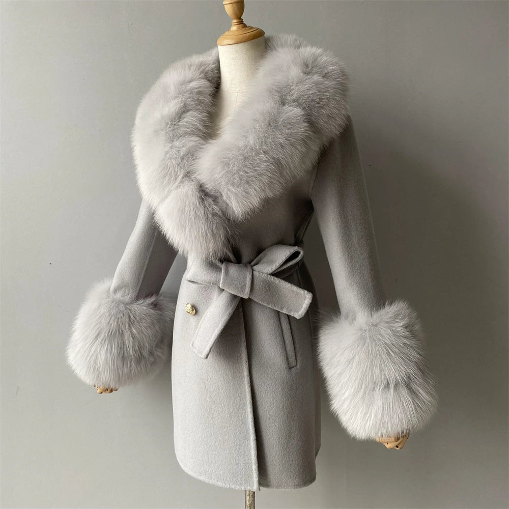 Gray coat with fur accents on a mannequin against a plain background