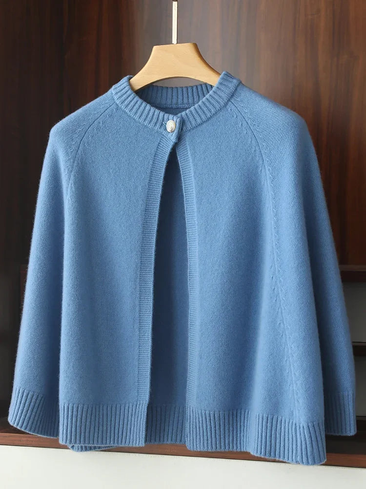 Blue knitted cardigan on a wooden hanger against a wooden background