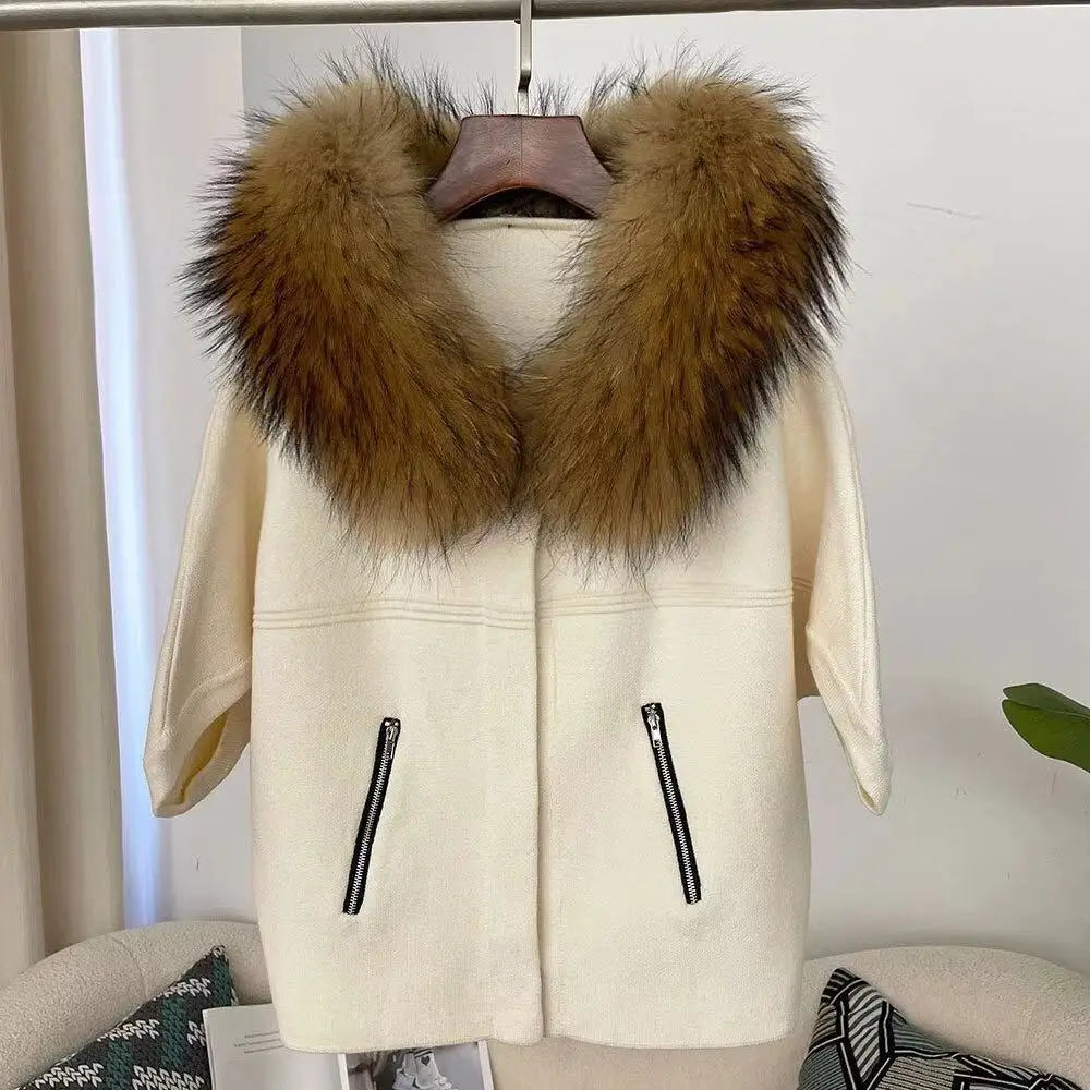 White coat with a fur collar on a hanger against a neutral background