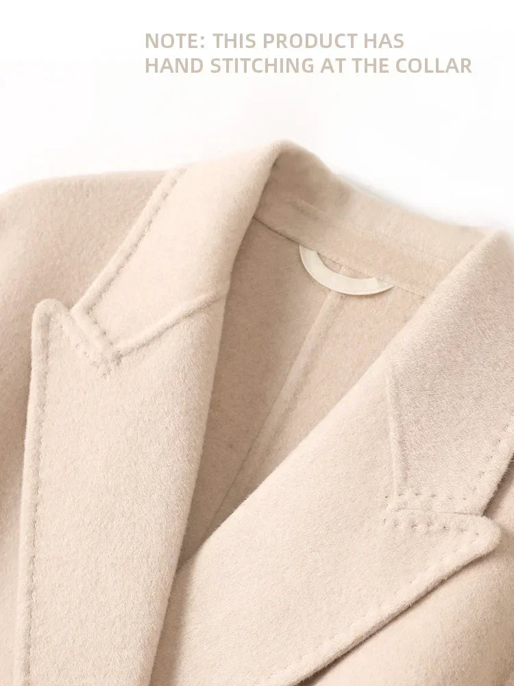 Close-up of a beige coat with hand stitching at the collar on a white background.