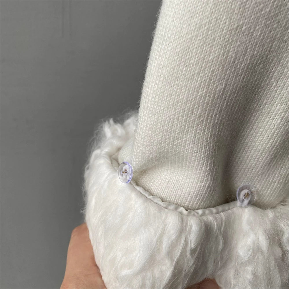 Close-up of a textured white sleeve with buttons against a gray background