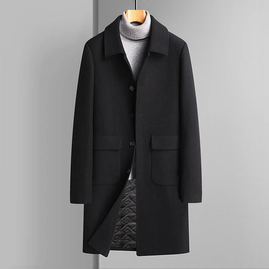 Black coat on a hanger against a gray background