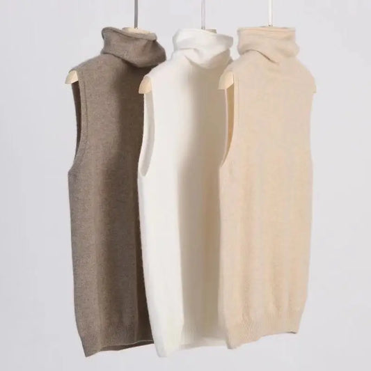 Three sleeveless garments in brown, white, and beige hanging against a light gray background.