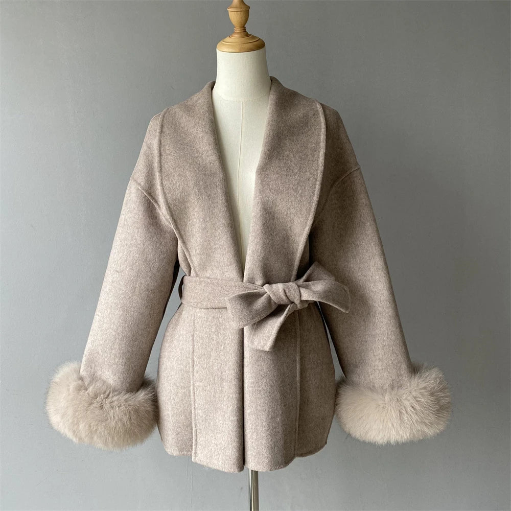 Beige coat with fur cuffs on a mannequin against a gray background