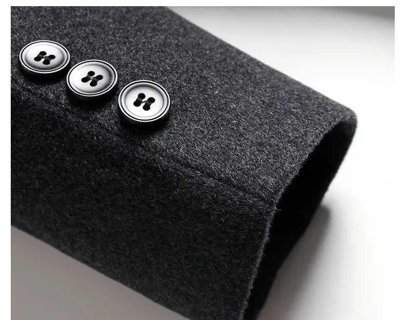 Close-up of a dark gray fabric sleeve with three buttons on a light gray background.