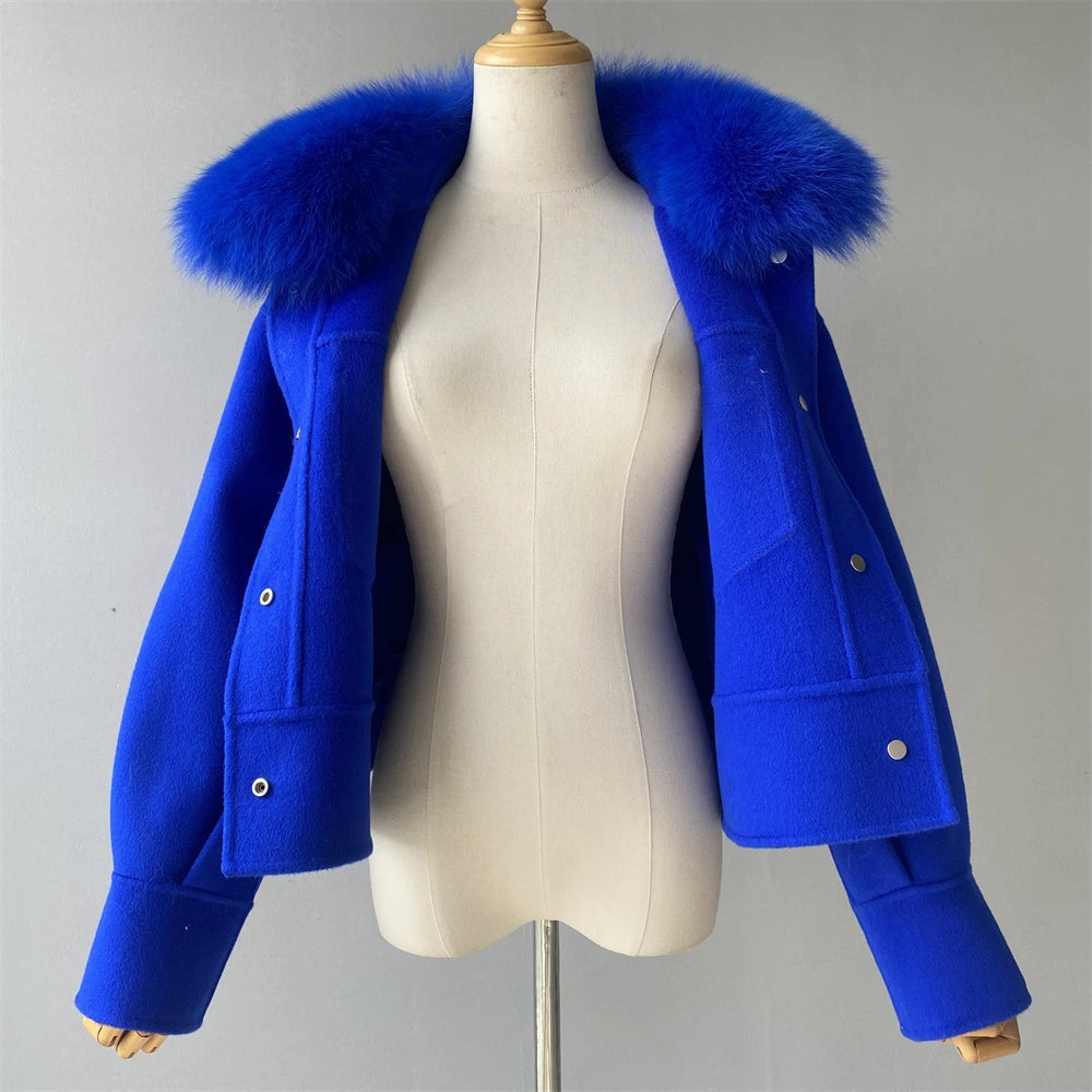 Blue coat with fur hood on a mannequin against a gray background