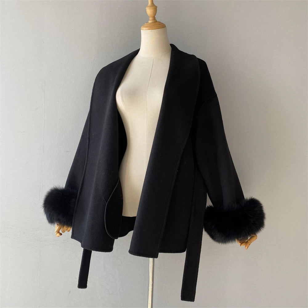 Black jacket with fur cuffs on a mannequin against a plain background