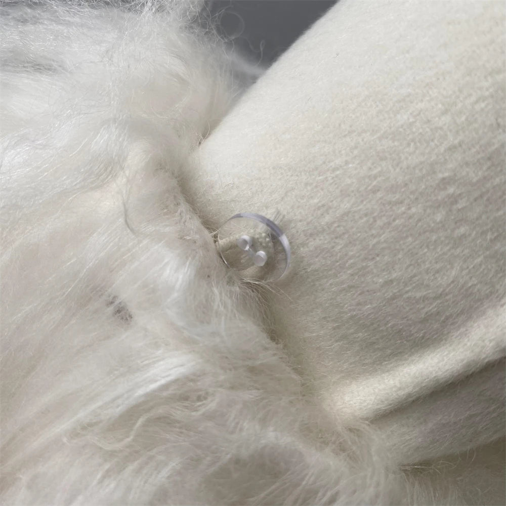 Close-up of white fur with a clear button on a dark background