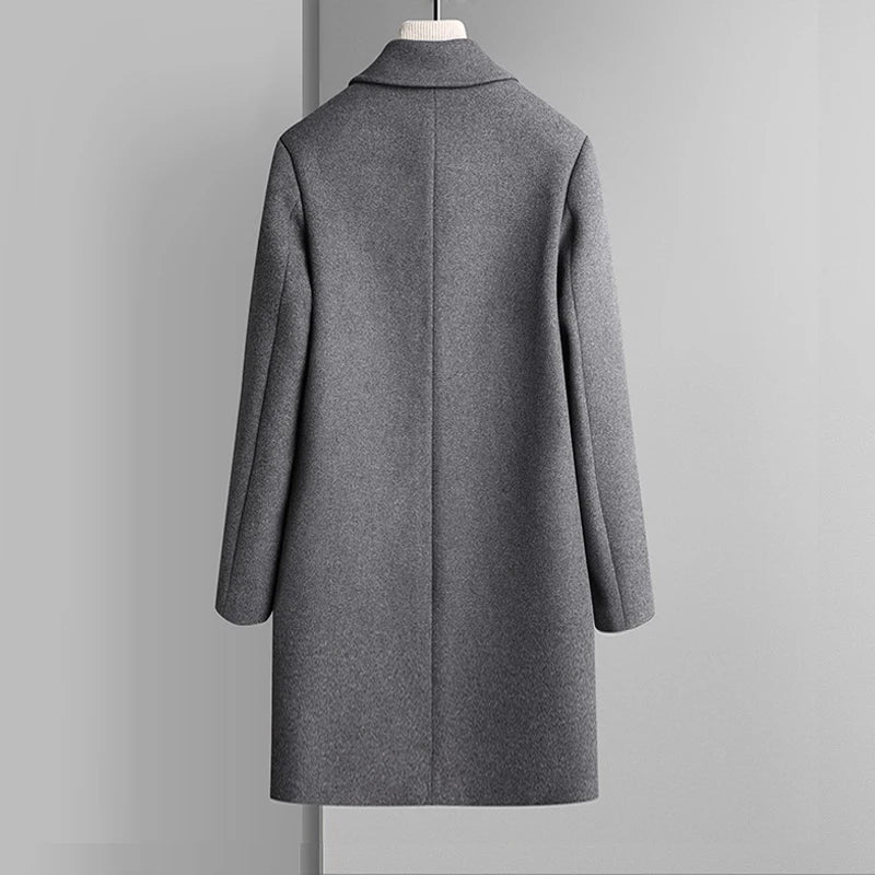 Gray coat on a mannequin against a plain background