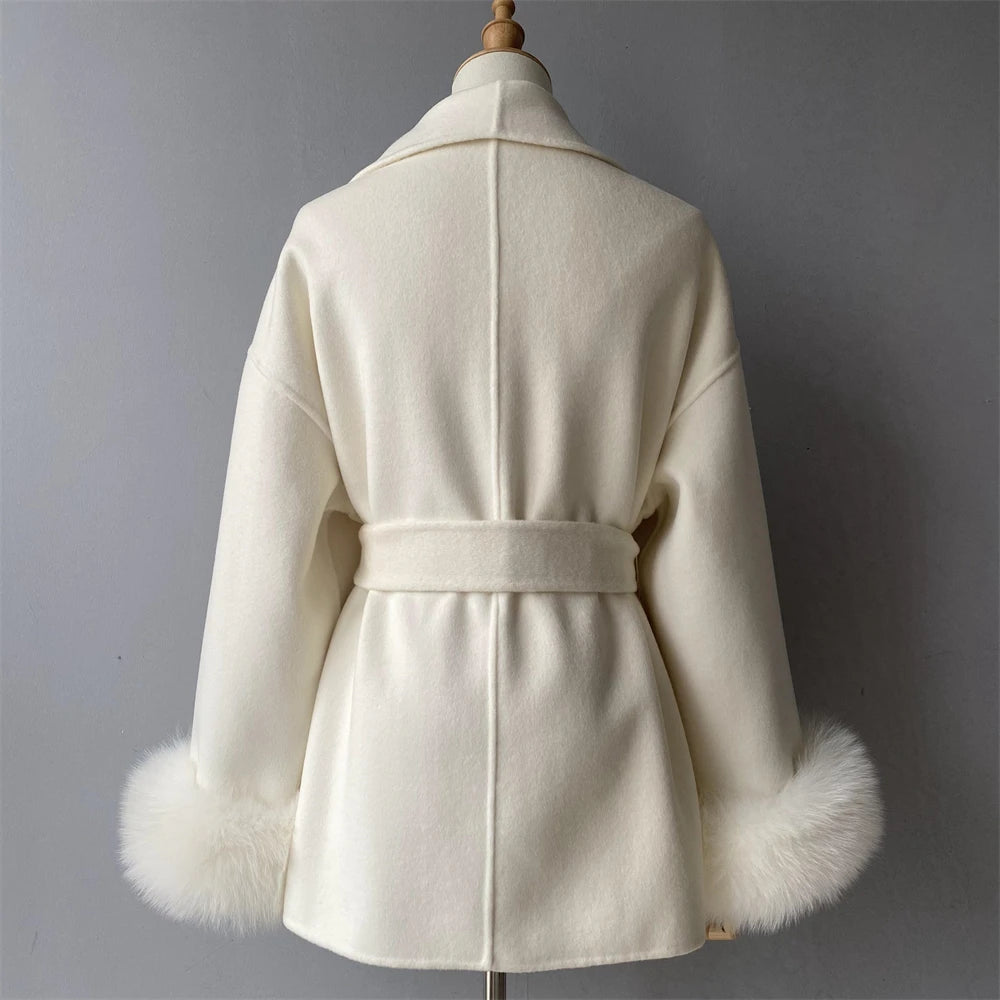 White coat with fur cuffs on a mannequin against a gray background