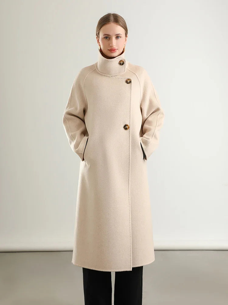 Woman wearing a beige coat against a plain background