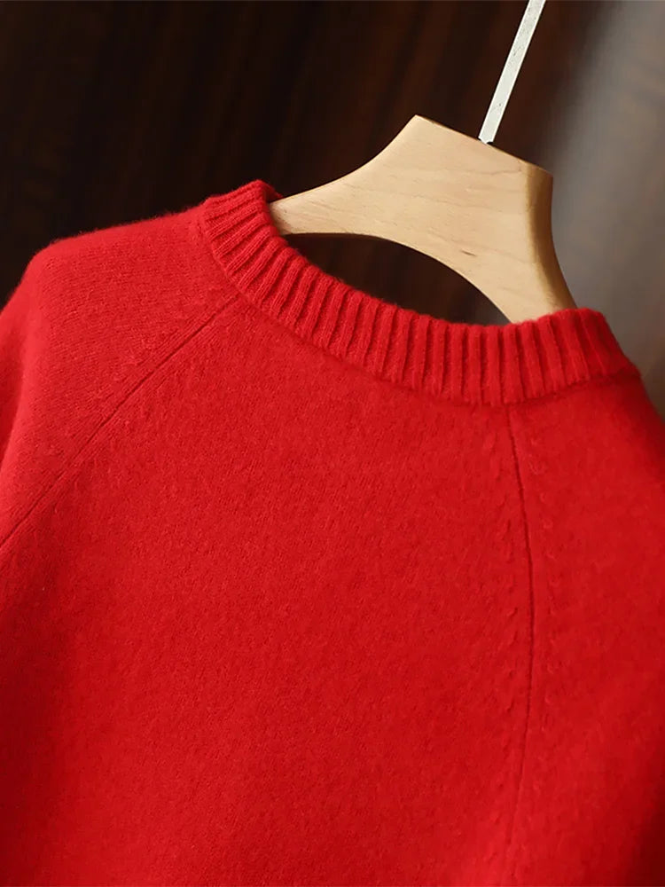 Red sweater on a wooden hanger against a dark background