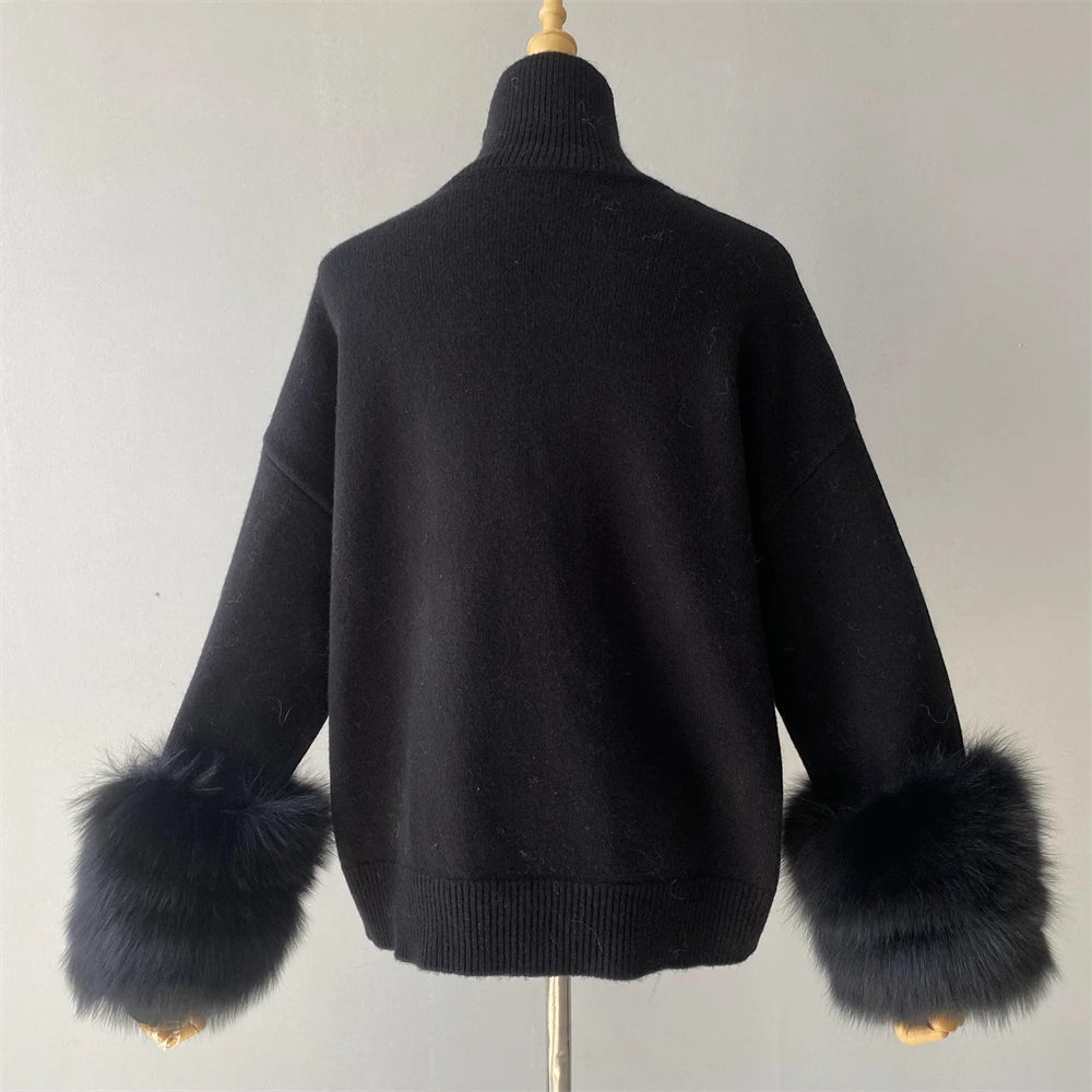 Black sweater with fur cuffs on a mannequin against a plain background