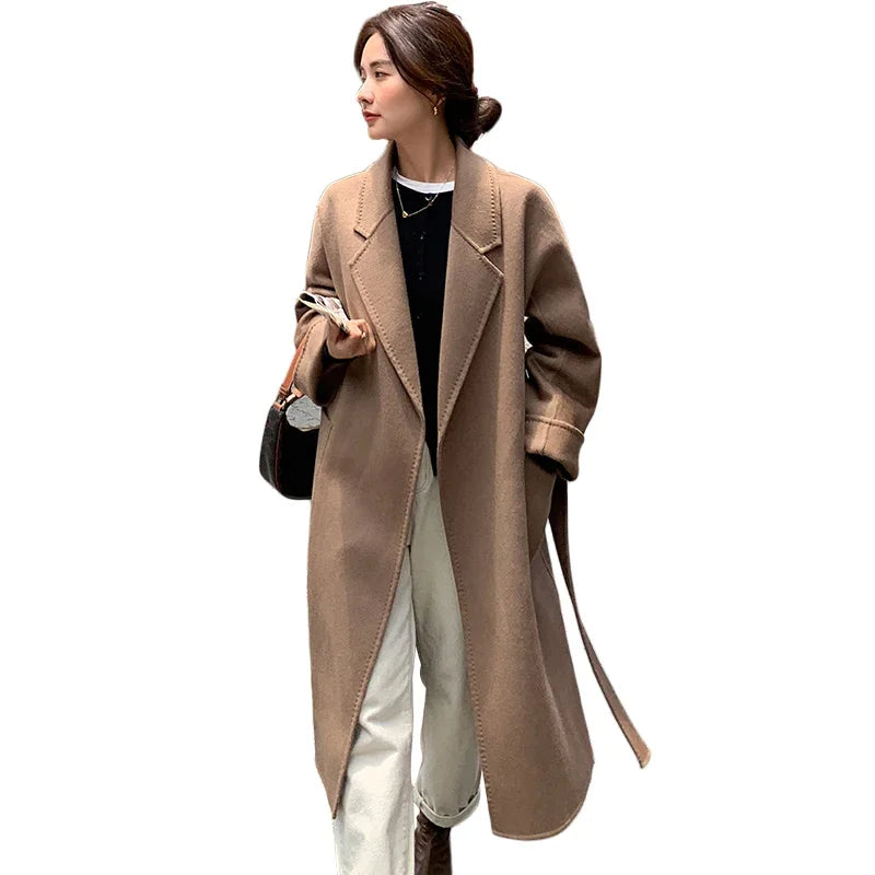 Woman wearing a long beige coat on a white background