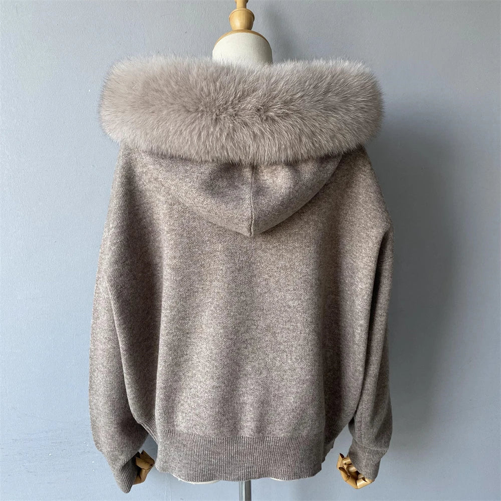 Gray sweater with fur hood on a mannequin against a light blue background