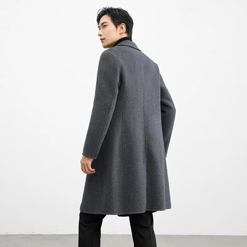Man wearing a gray overcoat against a white background