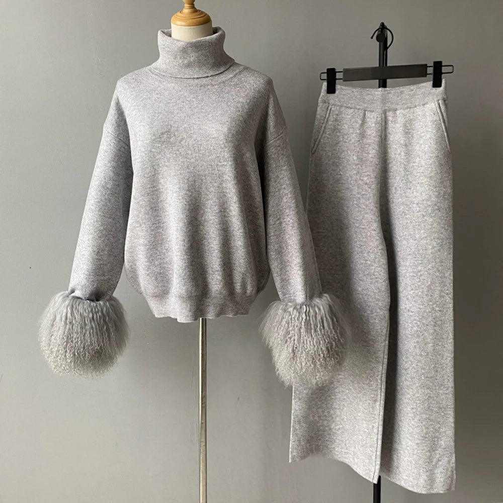 Gray sweater with fluffy cuffs on a mannequin and gray skirt on a hanger against a plain background