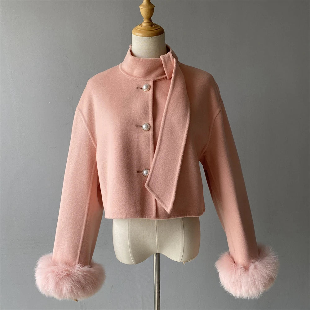 Pink jacket with fur cuffs on a mannequin against a gray background