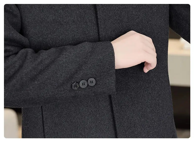 Close-up of a dark gray coat with buttoned cuffs, showing a hand adjusting the sleeve.