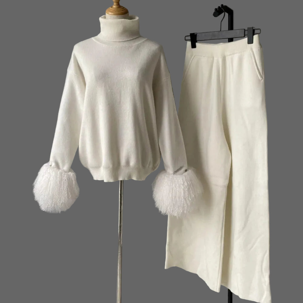 White sweater with feathered cuffs and a matching skirt on a gray background