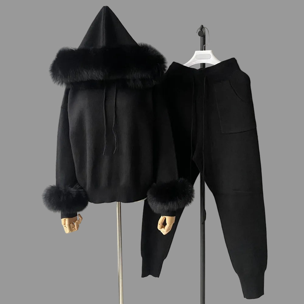 Black hoodie with fur trim and matching pants on a gray background