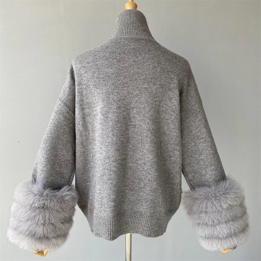 Gray sweater with fur cuffs on a mannequin against a plain background