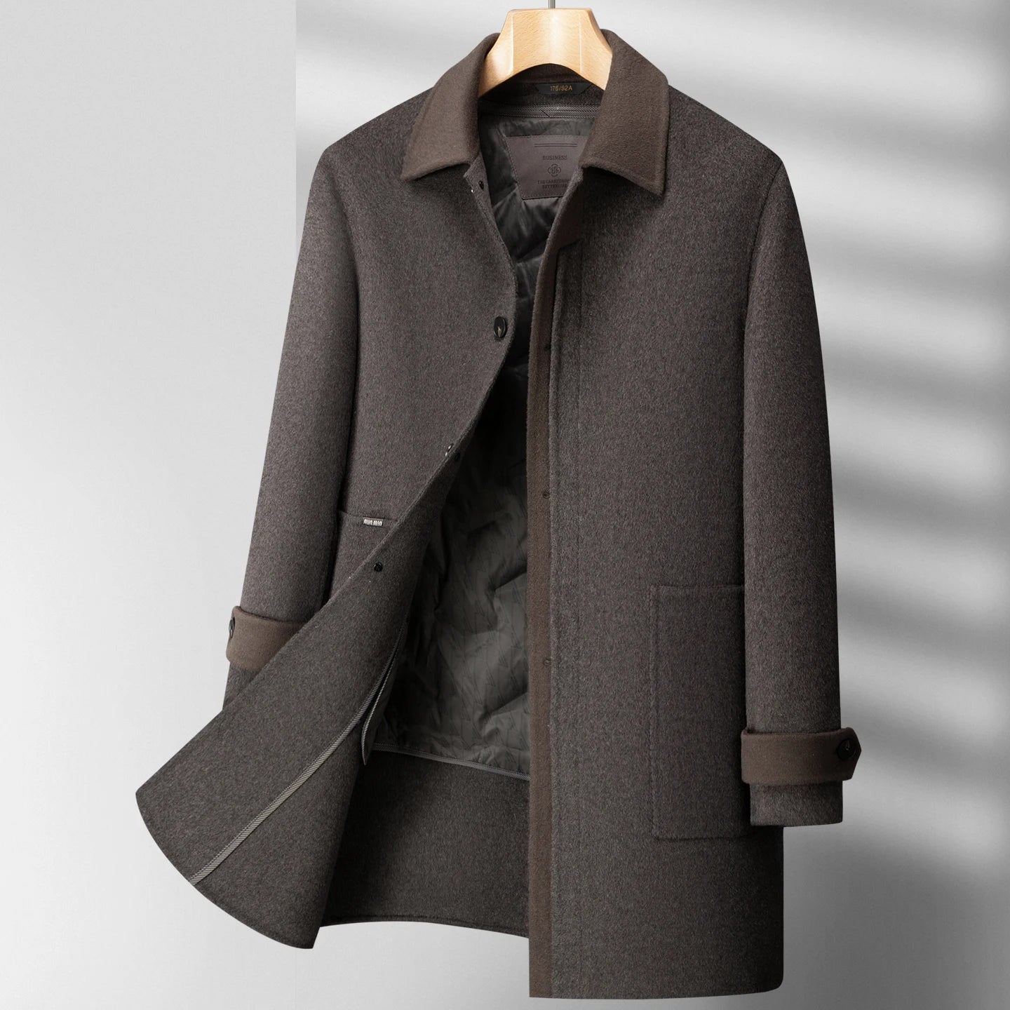 Gray coat on a hanger against a gray background