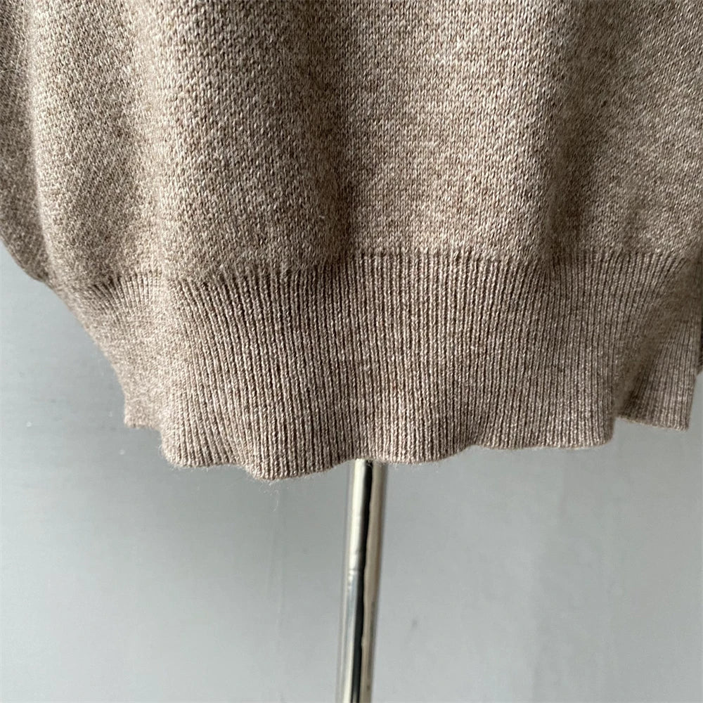 Beige sweater on a mannequin against a plain background