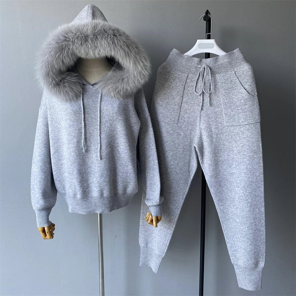 Gray hoodie with fur hood and matching pants on a mannequin against a gray background