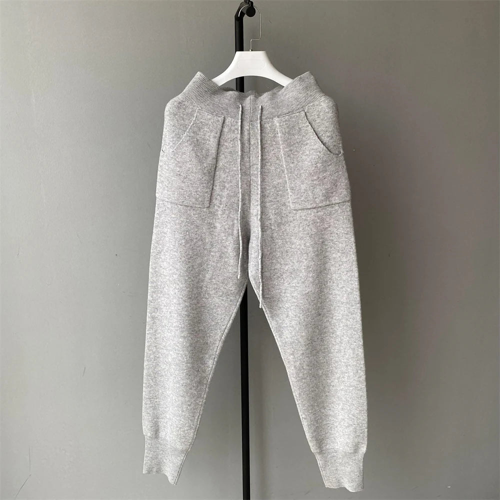 Gray sweatpants on a hanger against a plain background