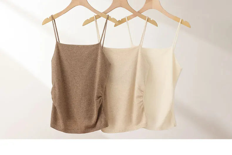 Two tank tops, one brown and one beige, hanging on wooden hangers against a white background.