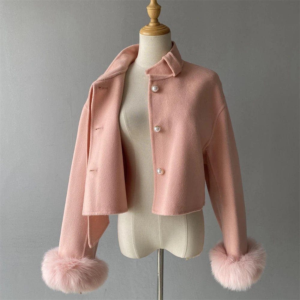 Pink coat with fur cuffs on a mannequin against a gray background
