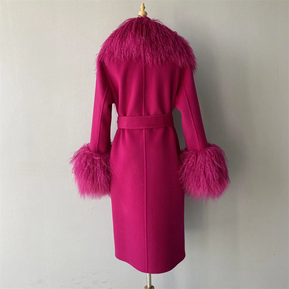 Pink coat with feathered cuffs and collar on a mannequin against a plain background